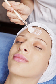 Attractive young Caucasian woman enjoying nourishing and moisturizing face mask