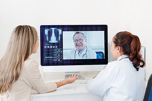 Doctor and female patient getting consultation of experienced senior Asian orthopedic surgeon online