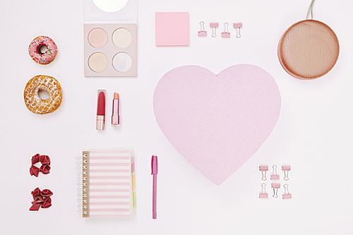 Image of notepad adhesive notes in the form of heart in pink color and cosmetics isolated on white