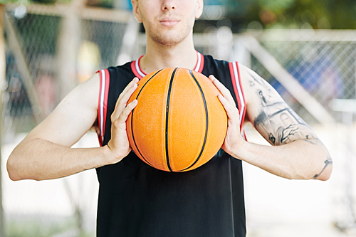 Cropped image of backetball player ready to throw a ball to camera