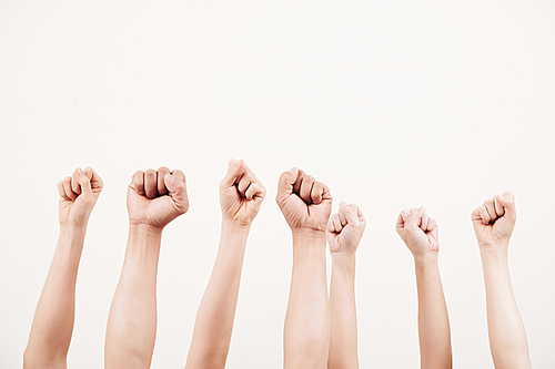 Close-up of business group raising their fists up and demonstrating power isolated on white