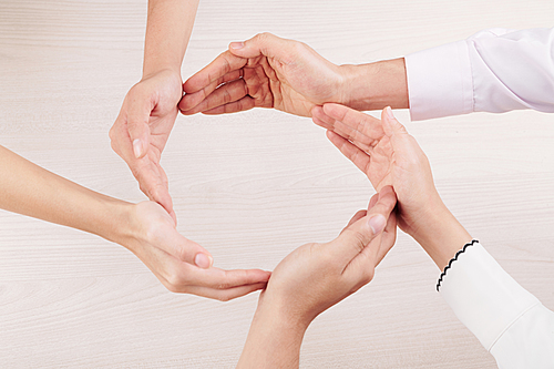 Group of people making circle from hands together and demonstrating their friendship and unity over white background