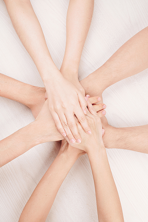 Close-up of Caucasian people holding hands together against the white background