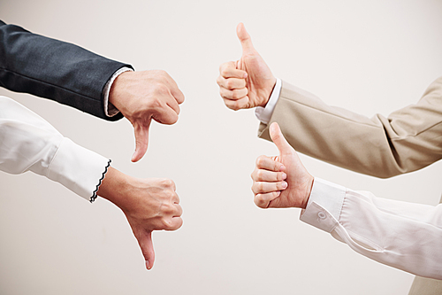 Group of two business partners showing thumb up and other two partners showing failure in business isolated on white