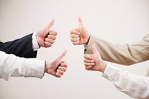 Close-up of business team showing thumbs up and symbolize success in business against the white background