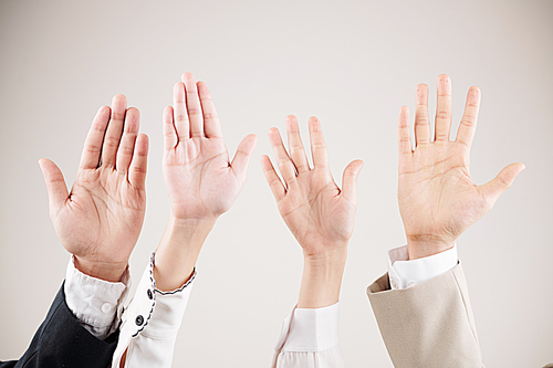 Close-up of multiethnic business people raising their arms up and waving over white background