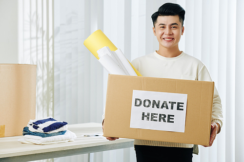 Portrait of happy excited handsome young Asian man with donation box