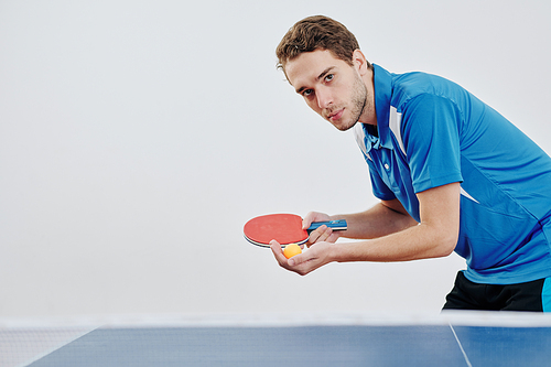 Serious young table tennis player ready to serve the ball