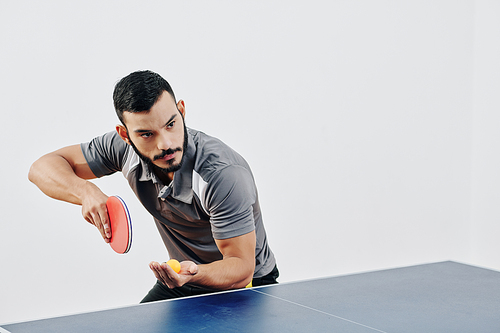 Professional table tennis player standing in certain position for serving ball and starting game
