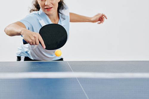 Professional female table tennis player hitting ball