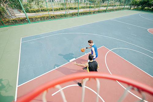 University students playing basketball on outdoor court