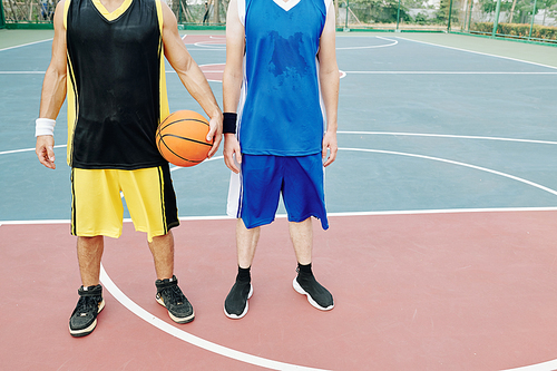 Sweaty young sportsmen tired after playing basketball on outdoor court