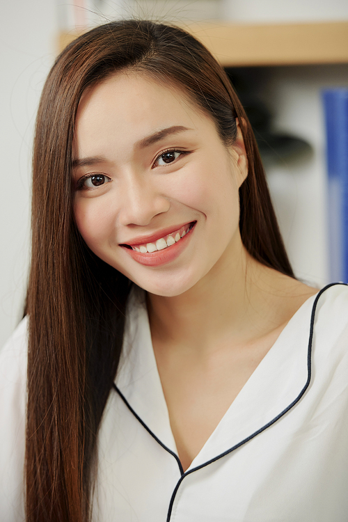Portrait of young beautiful Vietnamese female entrepreneur smiling at camera