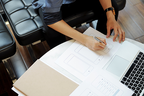 Close-up image of female UX designer drawing  of mobile application for new product