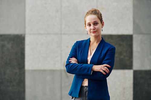 Portrait of young beautiful business lady  and folding arms to express confidence