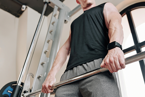 Fit muscular man doing deadlift exercises with heavy weight in gym