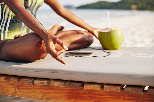 Woman holding hands in gyan mudra when meditating on sunny beach