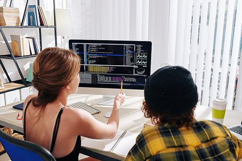 College students watching webinar on computer science at home and discussing programming code on computer screen