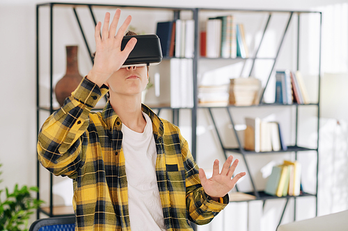 Teenager playing game in virtual reality glasses when staying home due to coronavirus outbreak