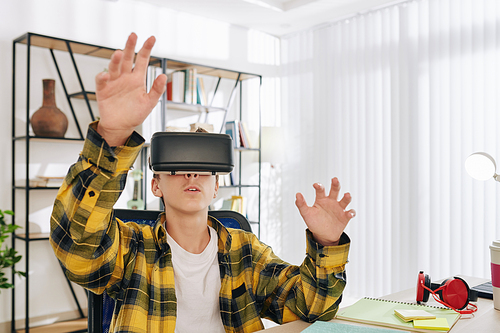 Teenage boy excited to test new game or educational application in virtual reality glasses