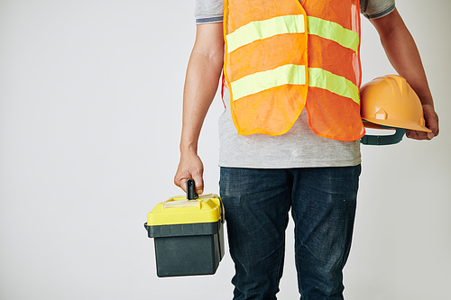 Cropped image of construction worker with toolbox and hardhat in his hands ready for work