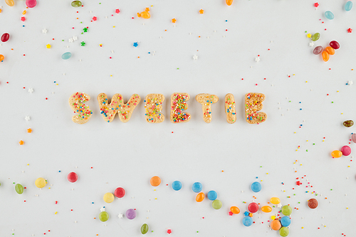 Word sweetie made of homemade sugar cookies and sprinkles adn candies around