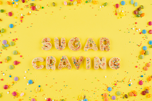 Sugar craving inscription made of sweet homemade cookies and colorful candies around