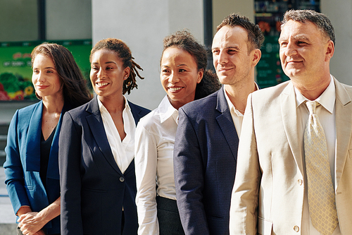 Smiling proud confident multi-ethnic business team posing outdoors