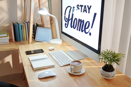 Stay home inscription on screen of computer of person working from home during pandemic