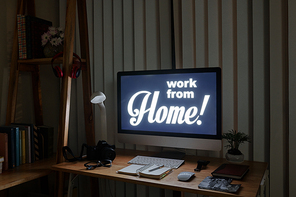 Dark home office of freelance photographer with computer with work from home inscription
