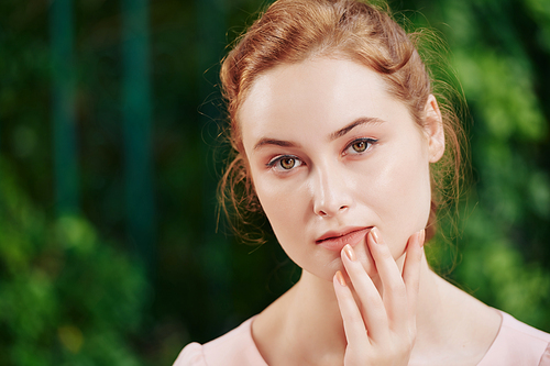 Portrait of young beautiful pensive woman with natural make-up looking at camera