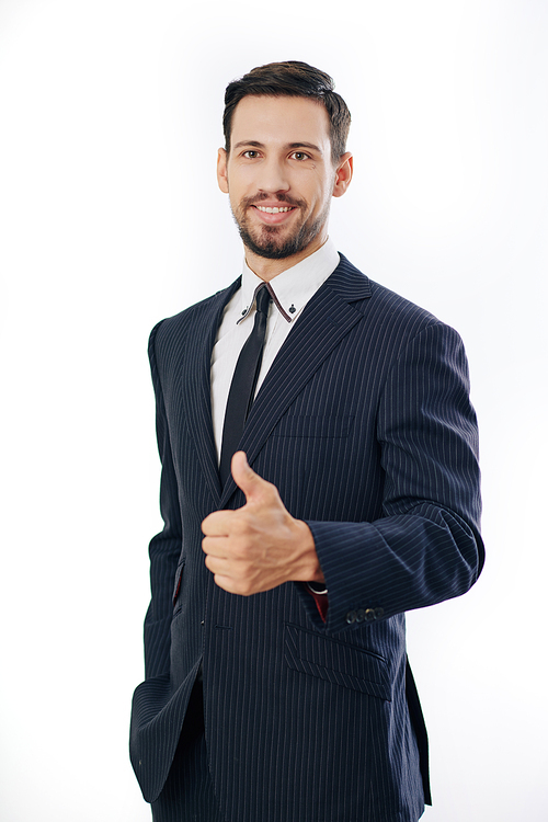 Portrait of cheerful young businessman showing thumbs-up and looking at camera, isolated on white