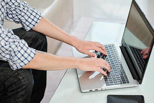 Close-up image of teenager working on laptop, sending e-mails or working on essay