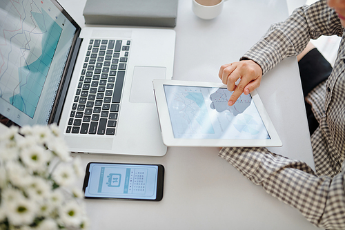 Businesswoman checking financial report on screen of tablet computer when analyzing sales