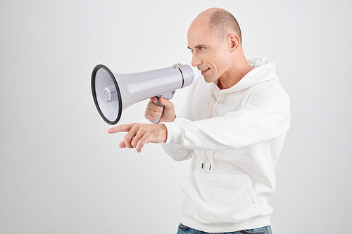 Studio portrait of middle-aged man in white hoodie talking with loudspeaker when