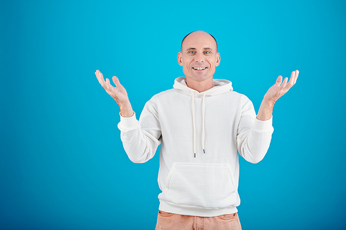 Studio portrait of happy middle-aged man in white hoodie looking at camera