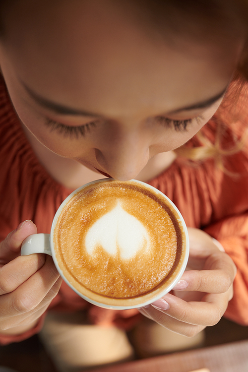 Woman enjoying cup of latte in ther morning, view from the top