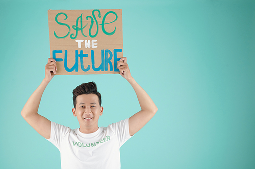 Portrait of cheerful young Vietnamese man asking people to save the future, isolated on turquoise