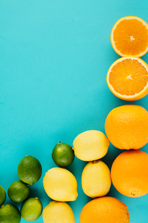 Juicy delicious oranges, lemons and limes on light blue background