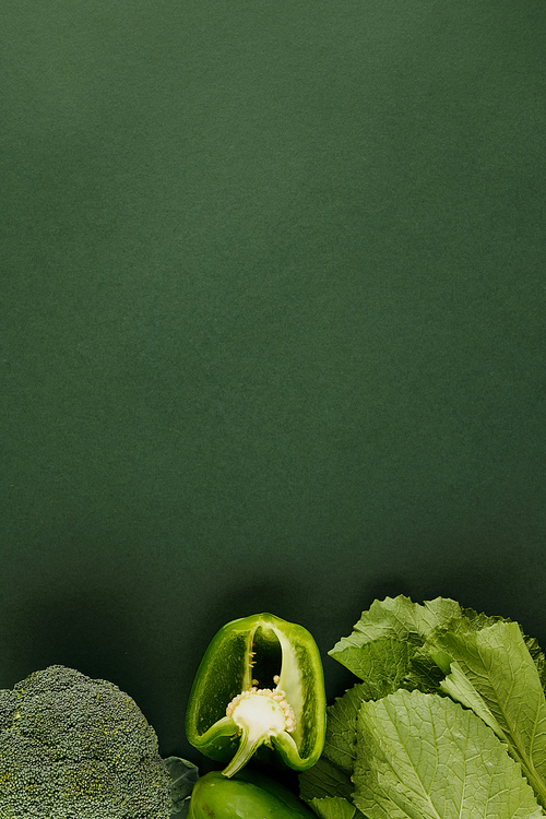 Fresh vegetables on green background like pepper, broccoli and lettuce