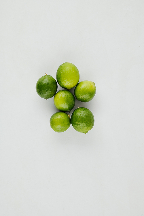 Green fresh juicy limes on grey table, view from above