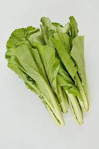 Pile of green juicy crunchy lettuce leaves on light grey background, view from the top