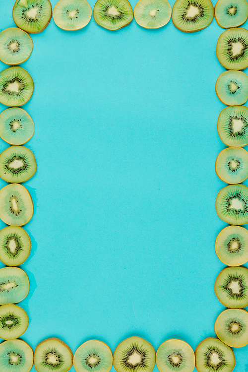 Bright blue background and frame made of thin juicy kiwi slices