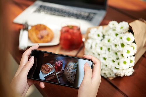 Woman taking beautiful photos of food and flowers for social media