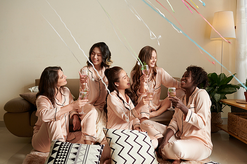 Happy diverse friends drinking margaritas at sleepover birthday party