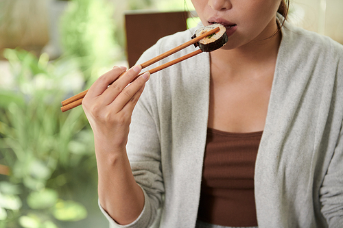 Cropped image of woman eating sushi for lunch