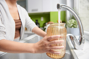 Woman changing water in glass flower vase