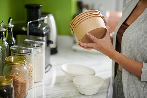 Cropped image of woman taking biodegradable bowls for soup and porridge
