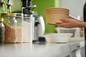 Woman taking out disposable bowls for breakfast oatmeal