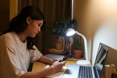 Vietnamese teenage girl using application on tablet computer when checking class schedule